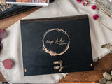 Black wooden box with personalized engraving and vintage clasp, designed for wedding photos